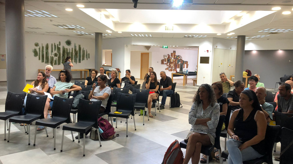 teachers sitting in an auditorium listening to a speaker