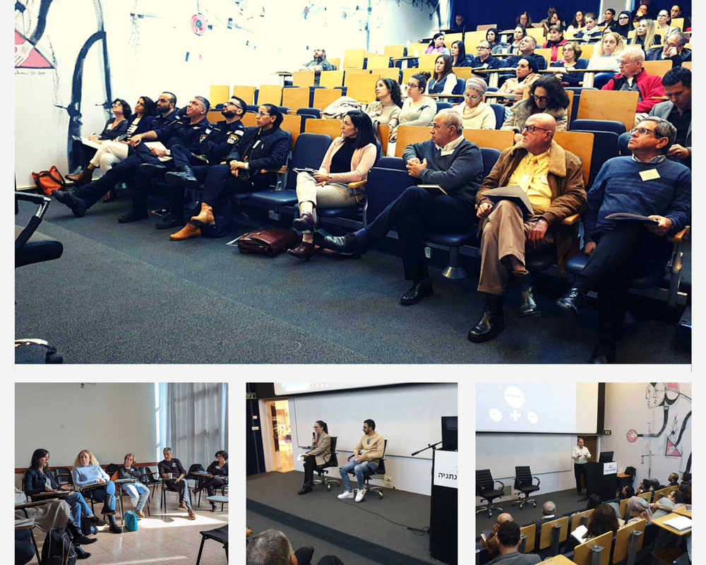 Attendees seated and looking towards a stage in an auditorium