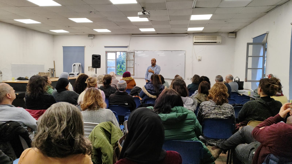 Faculty in a lecture facing a speaker stading in front of a whiteboard