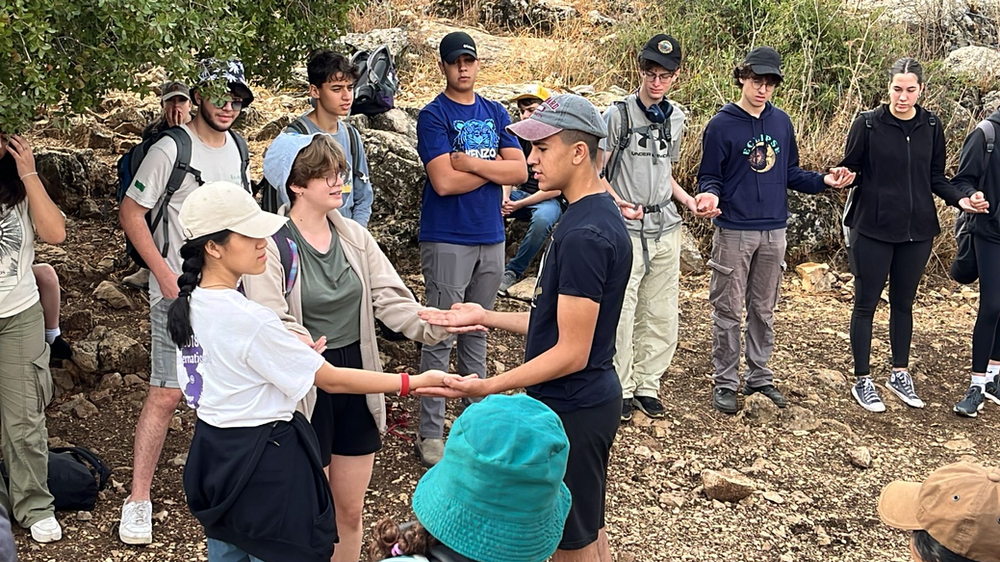 high school students standing outdoors engaging in an activity