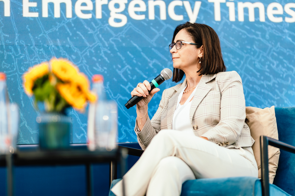 Professor Mona Khoury-Kassabri sitting with. a microphoe in her hand facing left