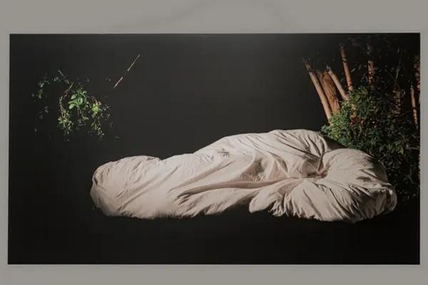 someone wrapped in a white blanked lying down