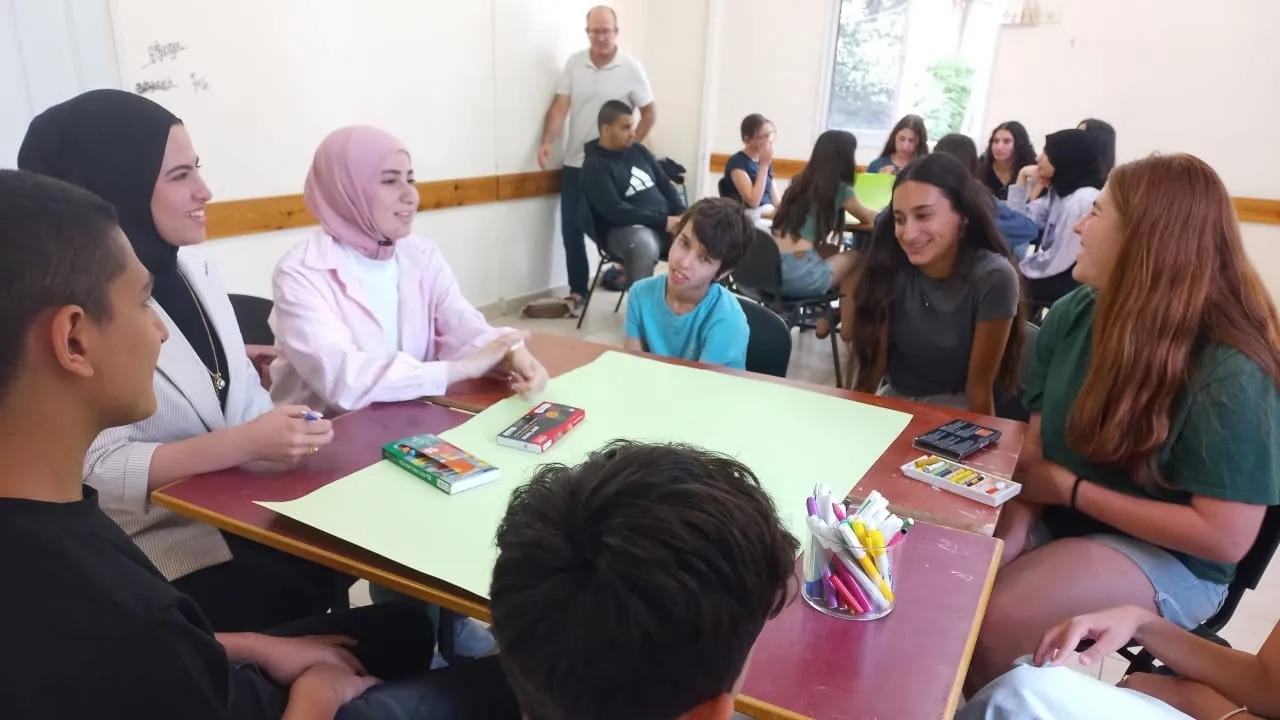 Girls sitting around a classroom table 