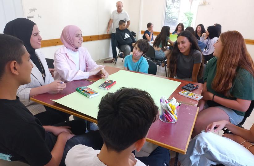 Youth sitting around a table talking to one another