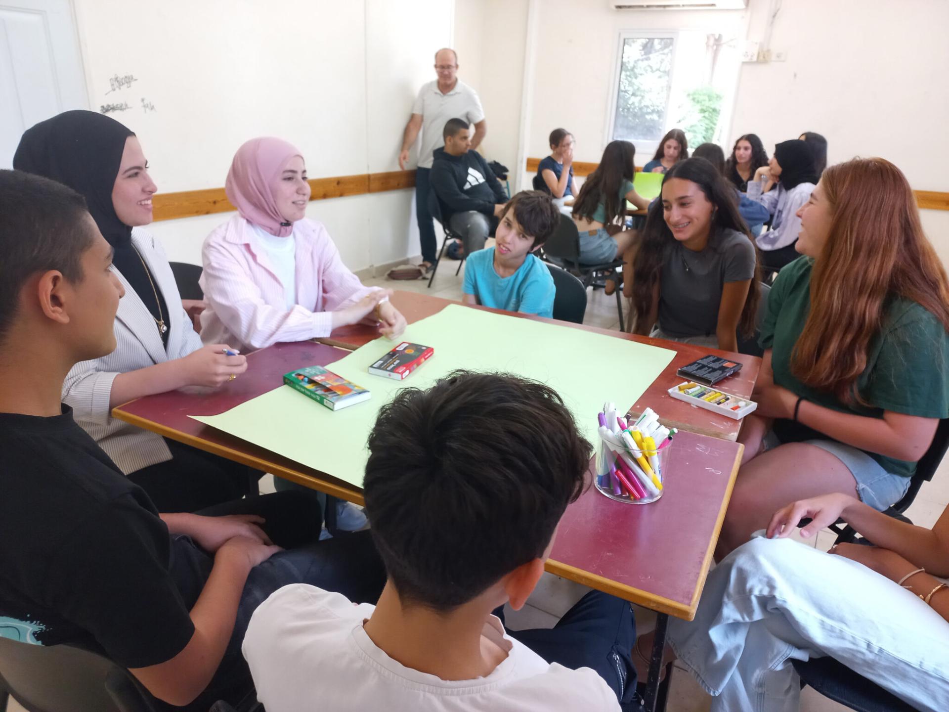 students sitting together at a table talking 