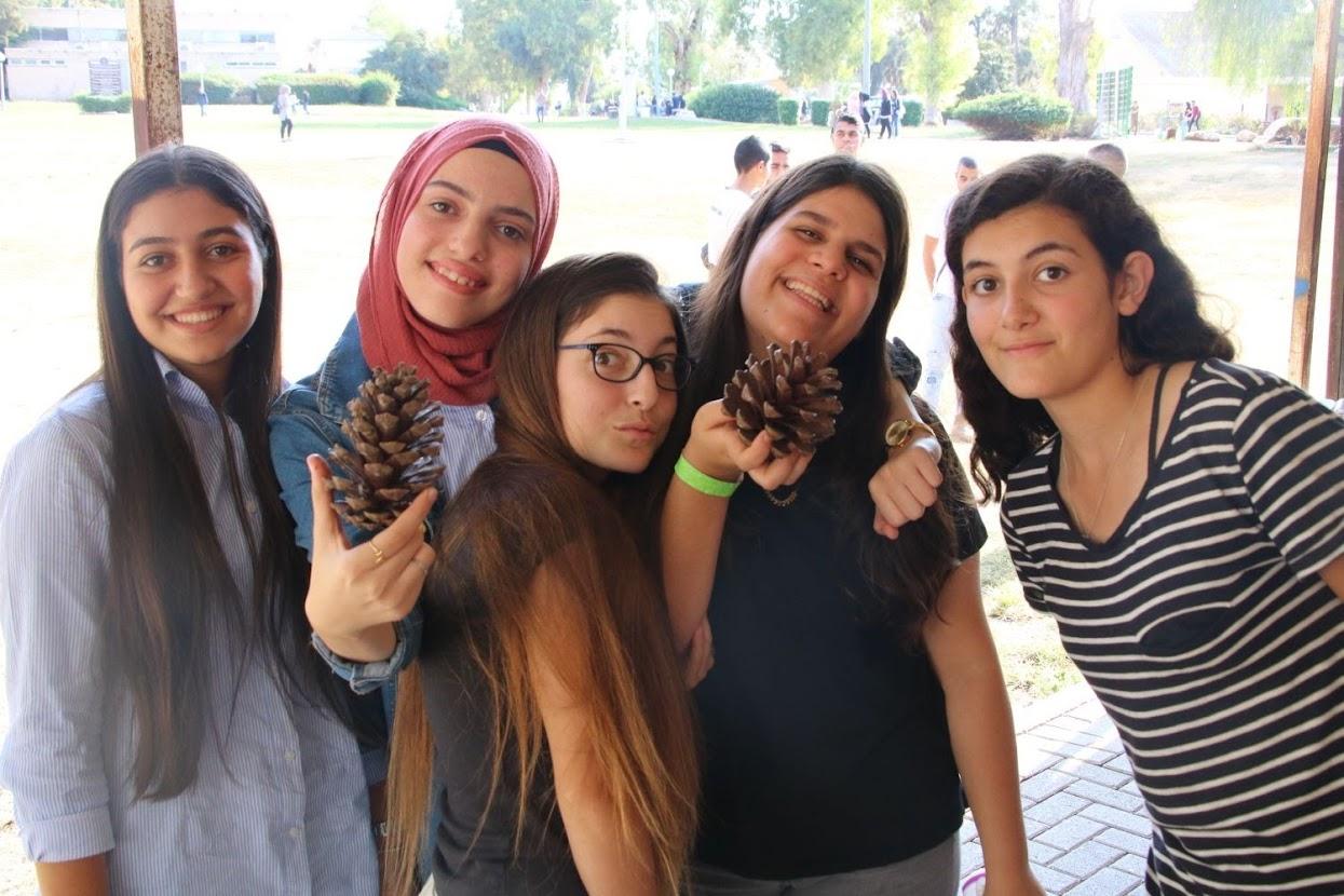 Teenage girls with giant pine cones